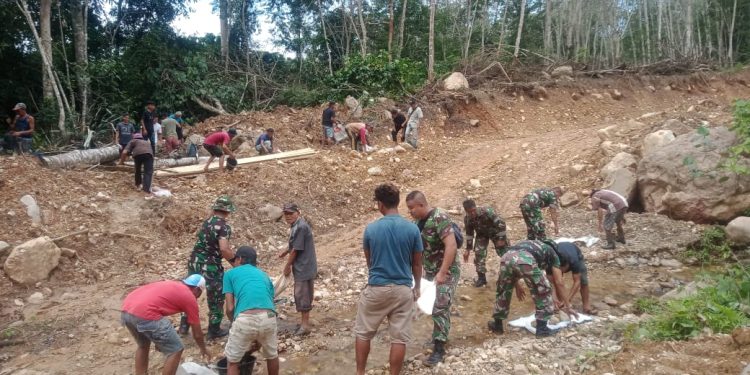 Personel Satgas TMMD Ke-119 Manfaatkan Batu-Batu yang Ada di Sekitaran Lokasi untuk Penimbunan Jalan yang Berlumpur